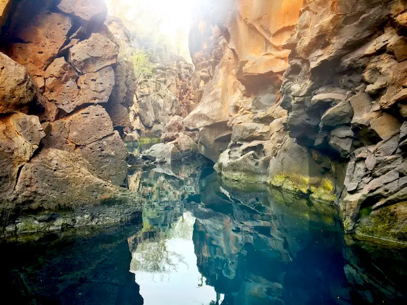 Blue water and jagged rock wall of Las Grietas, Galapagos