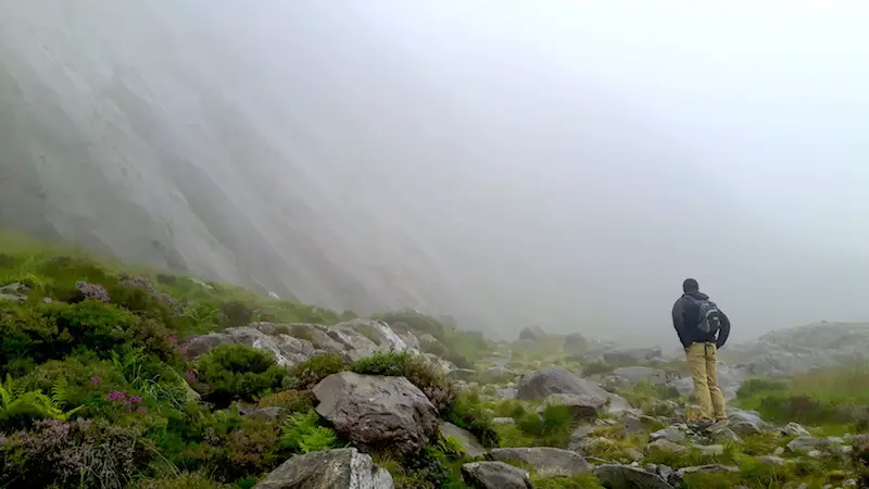 Sheer cliff face with a rocky landscape shrouded in clouds at Llyn Ogwen, Wales.