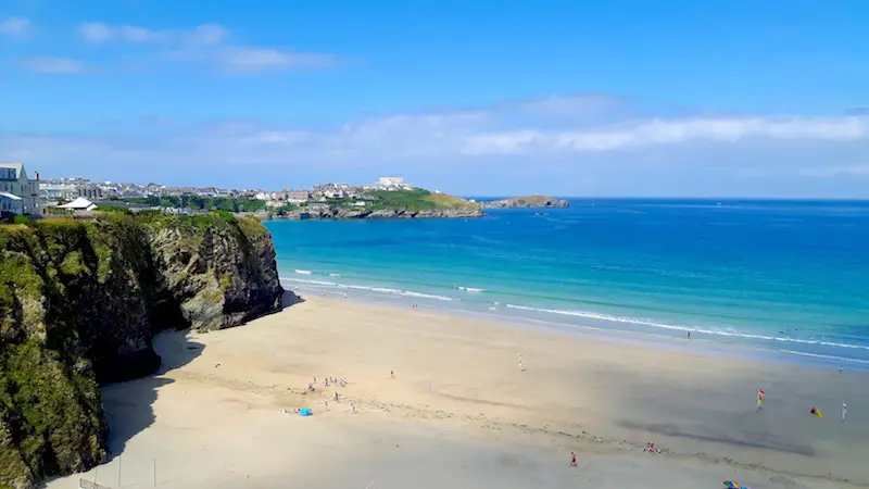 Picture perfect beach surrounded by cliffs and turquoise water in Newquay, Cornwall UK