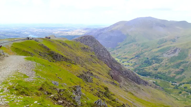 Steam train climbing Mount Snowdon with view across valley, Wales.