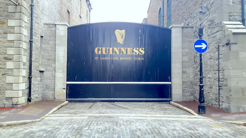 Black gate with gold lettering at St James's Gate Guinness Brewery in Dublin, Ireland.