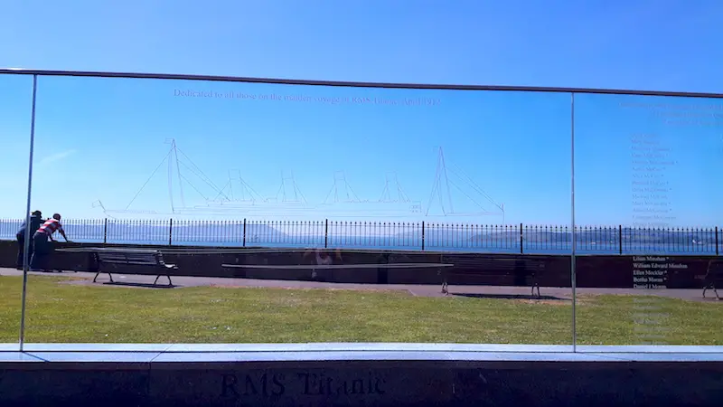 Glass wall with outline of HMS Titanic etched into it and names of passengers in Cobh, Ireland.