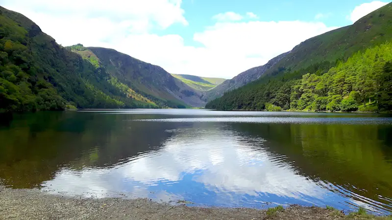 Green hills reflected in Upper Lake in Glendalough, Ireland.