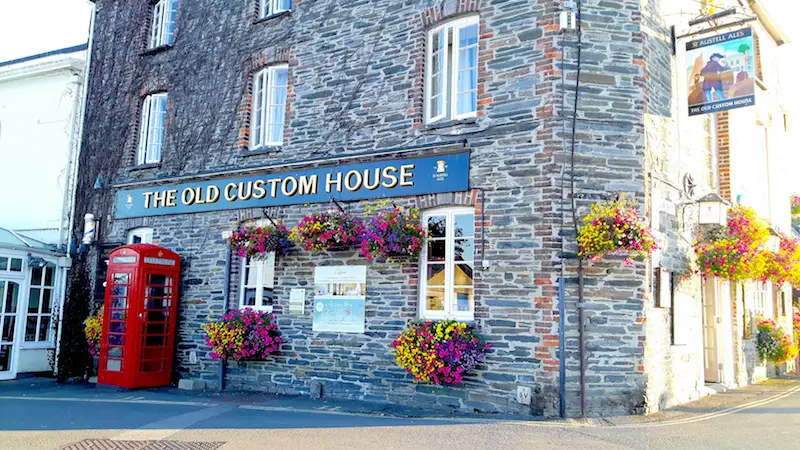 Traditional pub called "The Old Custom House" in Padstow, Cornwall with red phone box outside.