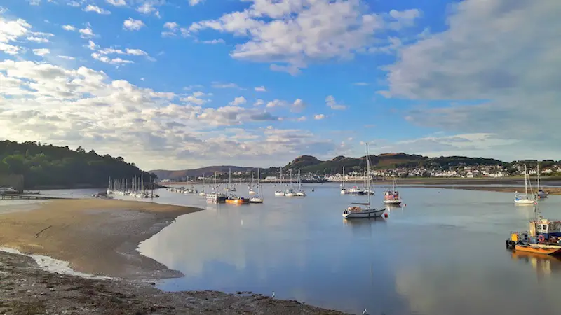 Boats at low tide in the river in Conwy, Wales.