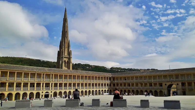 Inside the courtyard of the Piece Hall in Halifax with the historic building surrounding it and the spire of the church behind, Yorkshire England.