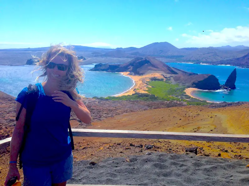 Woman at a lookout for pinnacle rock on Isla Bartolome with windswept hair in the Galapagos Islands.