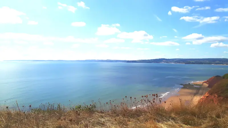 View across the cliffs, red sand and blue sea on the South West Coastal Path to Exmouth, Devon England.