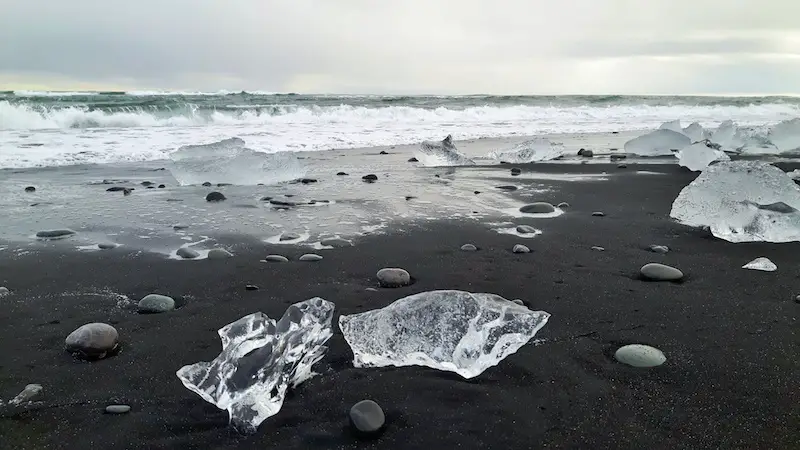 Chunks of clear ice on a black sand beach on the south coast of Iceland.