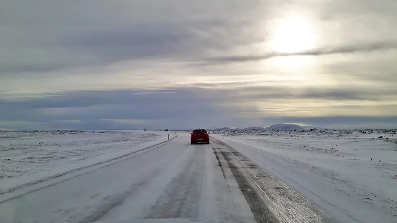 A car driving on the snow covered road to Dettifoss waterfall in Iceland