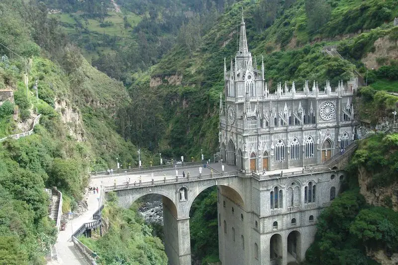 Large ornate church with very tall bridge spanning a lush green gorge in Ipiales, Colombia.