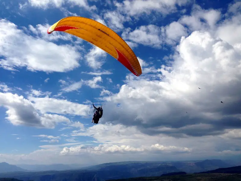 Tandem paragliding kite in the blue sky over San Gil, Colombia.