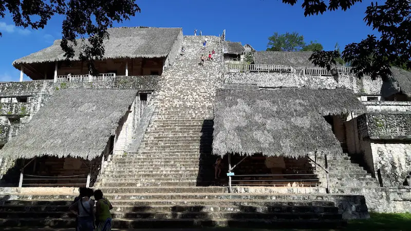 The tall stone stairway with palapa roofs sheltering sculptures up the Acropolis at Ek' Balam, Mexico.