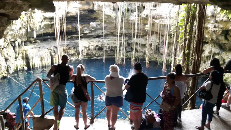 People looking down at Cenote Oxman, Valladolid Mexico.