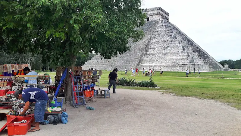 Vendors under a tree in front of the Kukulkan pyramid in Chichen Itza, Mexico