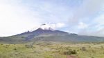 Snow-capped Cotopaxi volcano with steam rising from top in Ecuador.