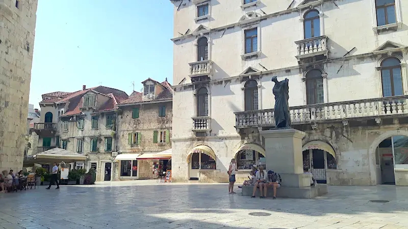 Old stone buildings around a square in the old town of Split, Croatia.