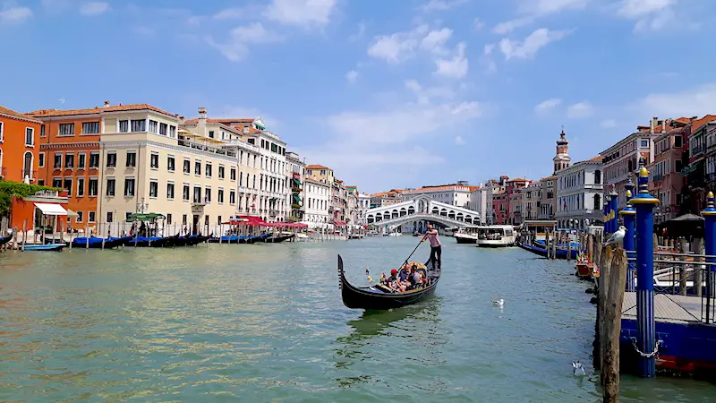 Gondola on Grand Canal with Rialto Bridge behind, Venice Italy.