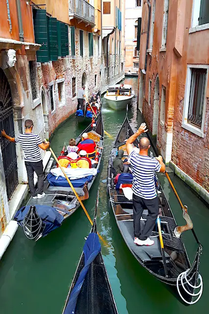 Line of gondolas on narrow Venice canal, Italy.